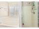 Modern bathroom featuring a tub, a separate shower, and a large window with shutters at 2813 N 107Th Dr, Avondale, AZ 85392