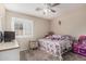Cozy bedroom features a ceiling fan, plantation shutters, and is adorned with toys and decorative accents at 2813 N 107Th Dr, Avondale, AZ 85392