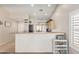 Open kitchen with bar and view into the dining area with lots of natural light at 2813 N 107Th Dr, Avondale, AZ 85392