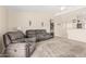 Living room with a ceiling fan, carpeting, slider, and comfortable seating that opens to kitchen at 2813 N 107Th Dr, Avondale, AZ 85392