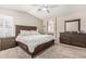 Cozy main bedroom with a ceiling fan, a large window with shutters and wooden furniture at 2813 N 107Th Dr, Avondale, AZ 85392