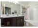 Bathroom with double vanity, dark cabinets, a tub, a shower, and decorative wall art at 29819 W Whitton Ave, Buckeye, AZ 85396