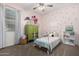 Charming bedroom with bright decor, including colorful wall art, patterned bedding, and a vintage dresser at 29819 W Whitton Ave, Buckeye, AZ 85396