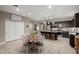 Open concept dining area featuring farmhouse decor, a kitchen island, and seating for four at the round table at 29819 W Whitton Ave, Buckeye, AZ 85396