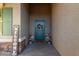 Charming entryway with a teal door, decorative wreath, and potted plants at 29819 W Whitton Ave, Buckeye, AZ 85396