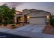 Charming single-story home featuring a two-car garage and welcoming desert landscaping at dusk at 29819 W Whitton Ave, Buckeye, AZ 85396
