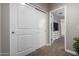 Hallway with closet featuring double doors leading into a bedroom with a dresser and tv at 29819 W Whitton Ave, Buckeye, AZ 85396