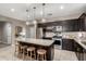 Bright kitchen featuring stainless steel appliances, dark cabinetry, and a granite-topped island with stool seating at 29819 W Whitton Ave, Buckeye, AZ 85396