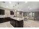 Open kitchen featuring dark cabinets, granite countertops, a central island, and an open concept design at 29819 W Whitton Ave, Buckeye, AZ 85396