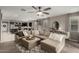 Open-concept living room showcases an oversized sectional couch, ceiling fan, and dining area in a warm neutral palette at 29819 W Whitton Ave, Buckeye, AZ 85396