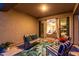 Inviting covered patio with comfortable seating, a vibrant rug, and view through sliding glass doors at 29819 W Whitton Ave, Buckeye, AZ 85396