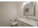 Neutral powder room with a single sink, a toilet, and a framed mirror with great lighting at 310 E Fremont Dr, Tempe, AZ 85282