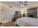 Cozy bedroom with a brick fireplace, wood floors, and a dresser with mounted TV at 310 E Fremont Dr, Tempe, AZ 85282