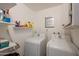 Bright laundry room equipped with a washing machine, a dryer, shelves, and storage cabinets at 310 E Fremont Dr, Tempe, AZ 85282