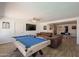 Open living room with a pool table, leather sofas, and access to the dining area at 310 E Fremont Dr, Tempe, AZ 85282