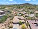An aerial view showcases a stunning home, surrounded by desert landscaping and community views with a mountainous backdrop at 31107 N 72Nd Pl, Scottsdale, AZ 85266