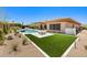 Beautiful backyard showcasing synthetic grass, desert landscaping, the pool and fire pit, and a neutral toned home at 31107 N 72Nd Pl, Scottsdale, AZ 85266