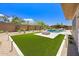A backyard oasis including artificial grass, a gas fire pit, desert landscaping and partial views of the pool at 31107 N 72Nd Pl, Scottsdale, AZ 85266
