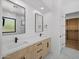 Bright bathroom with double sinks, marble countertops, and a walk-in closet with custom built-ins at 31107 N 72Nd Pl, Scottsdale, AZ 85266