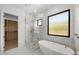 Bright bathroom featuring a glass shower, a soaking tub, and a walk-in closet with custom shelving at 31107 N 72Nd Pl, Scottsdale, AZ 85266