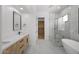 Modern bathroom with double sinks, marble countertops, a glass shower, and a soaking tub at 31107 N 72Nd Pl, Scottsdale, AZ 85266