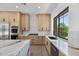 Modern kitchen featuring stainless steel appliances, custom cabinets, and a window with views of the backyard at 31107 N 72Nd Pl, Scottsdale, AZ 85266