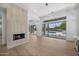 Bright living room with a fireplace, wood floors, and seamless indoor-outdoor living with pool view at 31107 N 72Nd Pl, Scottsdale, AZ 85266