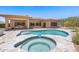 An inviting pool and spa surrounded by travertine tile, desert landscaping, and an elegant single story home at 31107 N 72Nd Pl, Scottsdale, AZ 85266