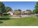 Charming single-story home featuring a landscaped front yard with mature trees and desert landscaping at 3357 N Ashbrook E St, Mesa, AZ 85213