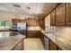 The kitchen features wood cabinets, tile floors, granite counters, and stainless steel appliances at 3357 N Ashbrook E St, Mesa, AZ 85213
