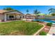 Expansive backyard with a pool, lounge area, covered patio, and a well-manicured lawn, perfect for entertaining at 3619 E Thornton Ave, Gilbert, AZ 85297