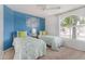Bright bedroom with two twin beds, a large window, and a decorative blue accent wall at 3619 E Thornton Ave, Gilbert, AZ 85297