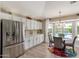 Charming breakfast nook featuring a stainless steel refrigerator, pool views, and custom lighting at 3619 E Thornton Ave, Gilbert, AZ 85297