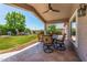 Inviting covered patio featuring a dining table set, ceiling fan, and views of the lush green backyard at 3619 E Thornton Ave, Gilbert, AZ 85297