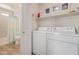 Functional laundry room with washer, dryer, shelving and a combined shower/toilet room at 3619 E Thornton Ave, Gilbert, AZ 85297