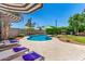 Serene backyard pool area featuring lounge chairs, shade umbrellas, and well-maintained landscaping at 3619 E Thornton Ave, Gilbert, AZ 85297