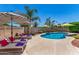 Beautiful backyard pool area with lounge chairs, umbrellas, and lush landscaping for outdoor enjoyment at 3619 E Thornton Ave, Gilbert, AZ 85297