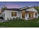 Twilight view of home's exterior with manicured lawn, modern design, and covered patio, offering serene outdoor living at 3848 E Fairmount Ave, Phoenix, AZ 85018