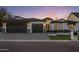 Elegant home exterior features a three-car garage, white brick accents, and a well-manicured front yard at 3848 E Fairmount Ave, Phoenix, AZ 85018