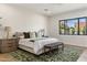 Bright main bedroom with hardwood floors, stylish rug, and a view to the outdoors at 3848 E Fairmount Ave, Phoenix, AZ 85018