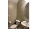 Cozy bathroom with a pedestal sink, toilet, and a round mirror at 3900 E Baseline Rd # 166, Phoenix, AZ 85042