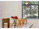 Close-up of a wood dining table with red roses in a vase in front of a window at 3900 E Baseline Rd # 166, Phoenix, AZ 85042