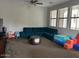 Bright living room featuring a comfortable blue couch, windows, and ceiling fan at 3900 E Baseline Rd # 166, Phoenix, AZ 85042