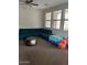 Spacious living room with large windows and an L-shaped blue couch at 3900 E Baseline Rd # 166, Phoenix, AZ 85042