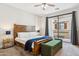 Well-lit main bedroom with a wood bed frame and sliding glass doors leading to a patio at 3900 E Baseline Rd # 166, Phoenix, AZ 85042