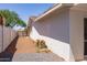 A view of the backyard with a gravel surface, partial view of the exterior wall, and a metal gate at 4116 W Marshall Ave, Phoenix, AZ 85019