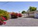 The gravel backyard offers a covered patio and vibrant bougainvillea adding to the property's appeal at 4116 W Marshall Ave, Phoenix, AZ 85019