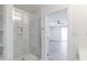 Sleek shower design with white marble tiling in a modern bathroom with a gray-floored room beyond at 4116 W Marshall Ave, Phoenix, AZ 85019