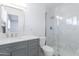 Modern bathroom features a gray vanity, framed mirror, and tiled shower at 4116 W Marshall Ave, Phoenix, AZ 85019