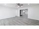 View of the open living room with gray wood flooring, and view to kitchen area in a modern home at 4116 W Marshall Ave, Phoenix, AZ 85019